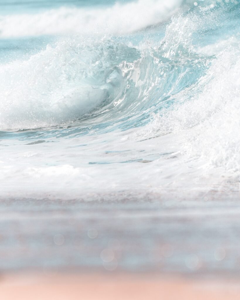 Scenic view of foamy blue sea wave rolling on shore on clear day