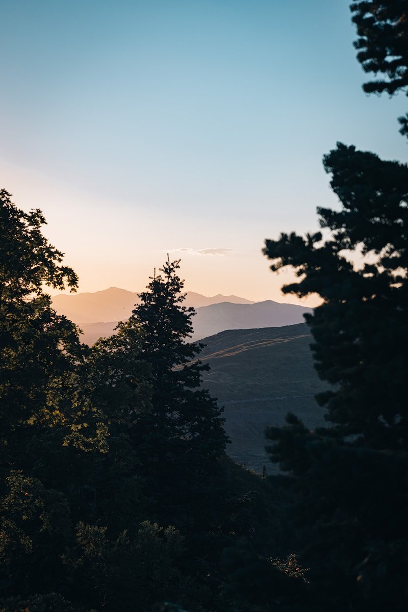 the sun is setting over the mountains in the distance