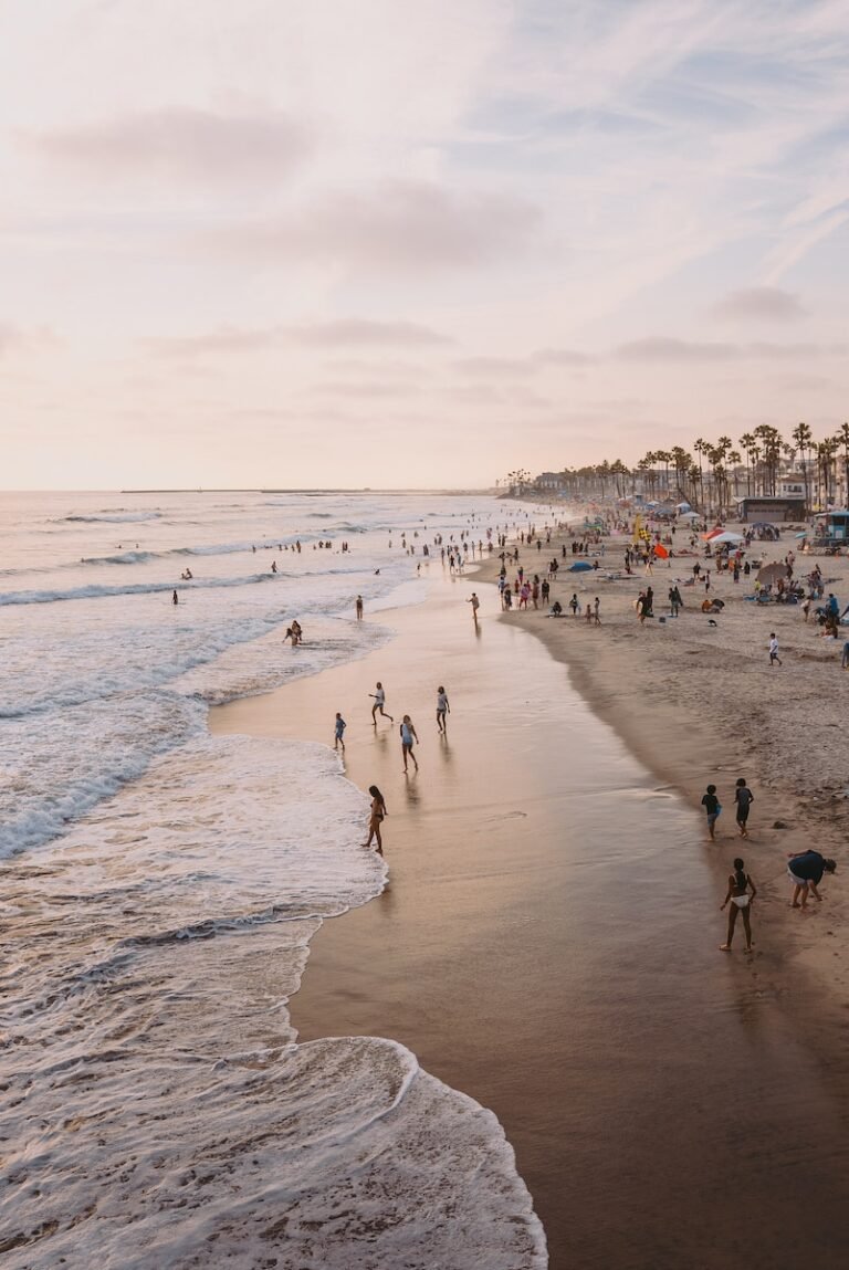 many people are walking on the beach near the water