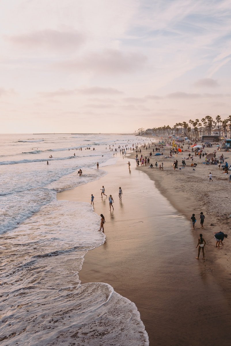 many people are walking on the beach near the water