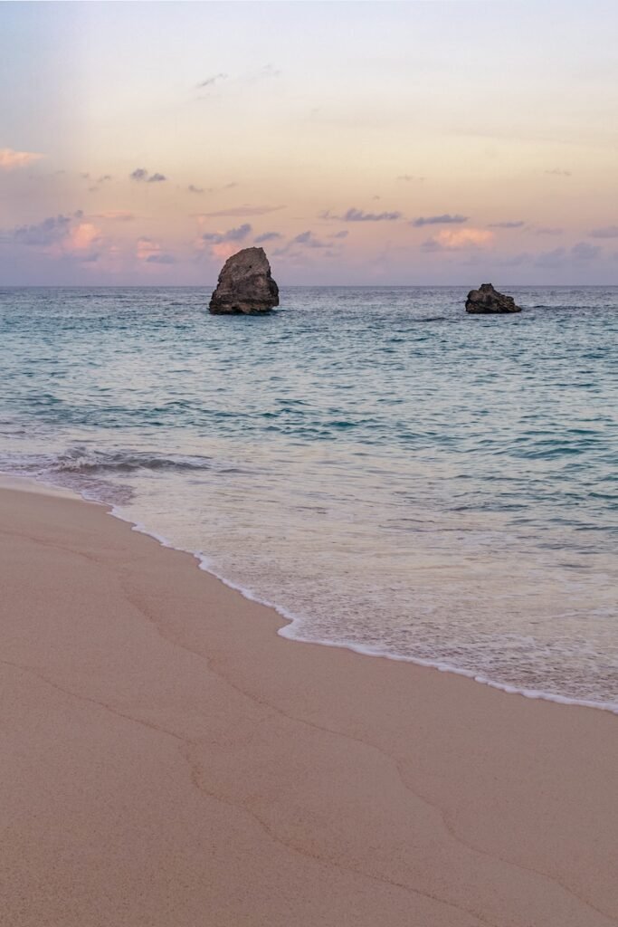 a person walking on the beach with a surfboard