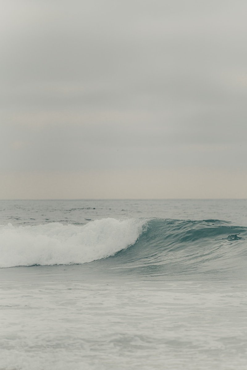 a man riding a wave on top of a surfboard