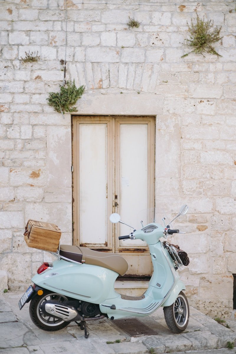 a blue scooter parked in front of a door