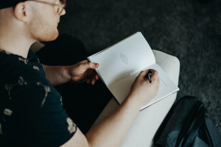 man in black t-shirt holding white printer paper