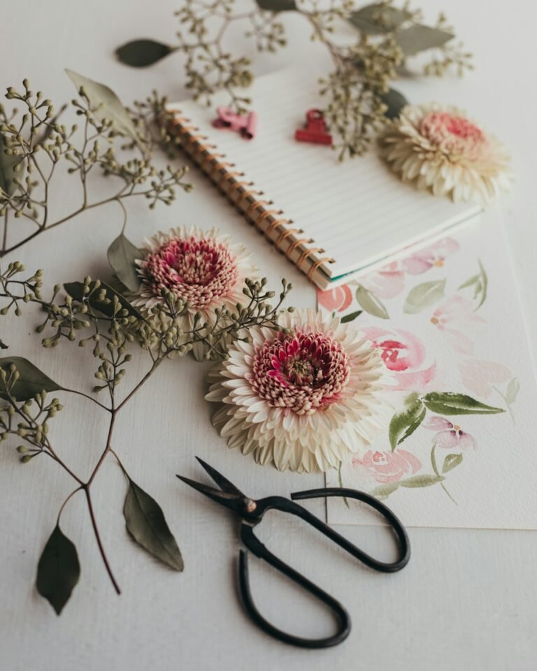 a pair of scissors sitting on top of a table next to flowers